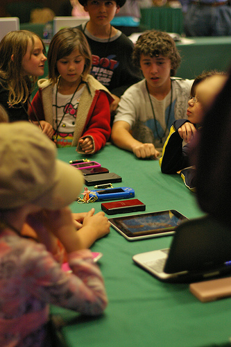 Kids looking at mobile tech on Flickr by soopahgrover