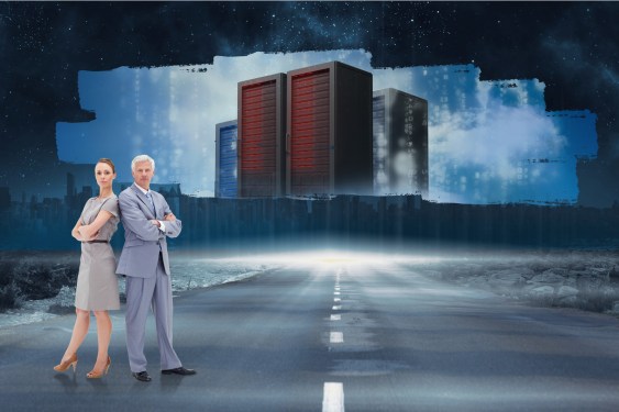 Man and woman standing back to back in front of server towers.