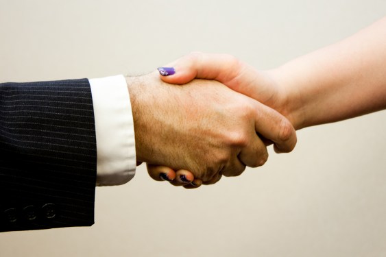 Man and woman shaking hands with just view of their hands.