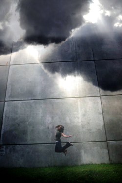Clouds coming together and girl jumping on platform.