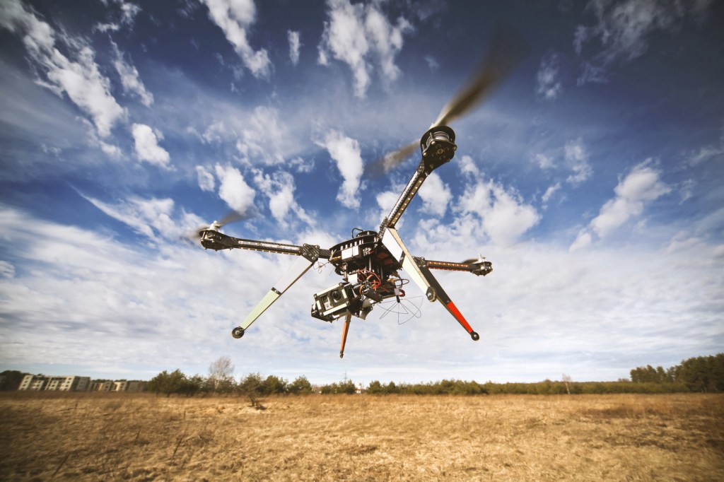 Drone flying against blue sky.
