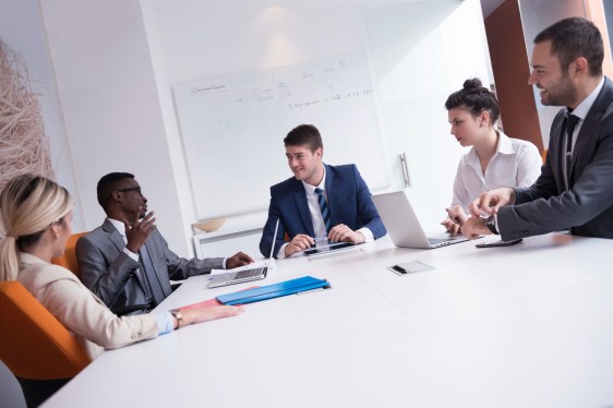 Group of workers meeting around conference table.