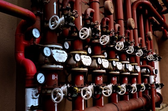 Series of red pipes with gauges attached to each one signifying pressure being applied.