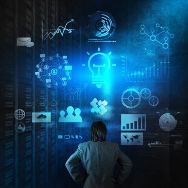 Person standing in front of walls with various data sources.