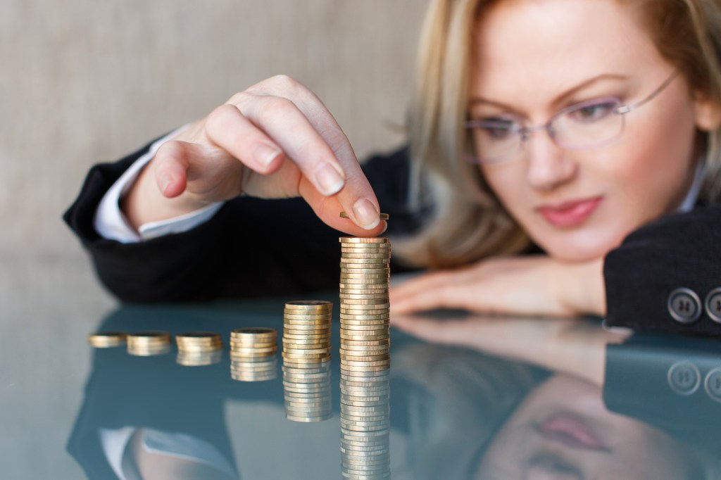 Woman counting piles of coins