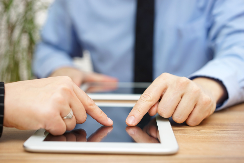 business man and business woman working on a tablet.