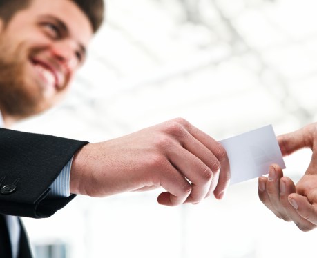 Sales person giving client his card.