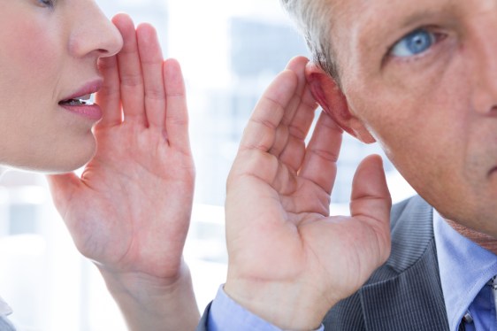 woman whispering in man's ear