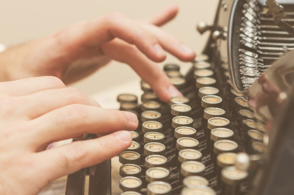 person typing on an old-school typewriter