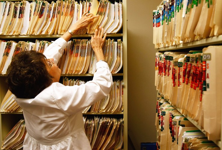 WALSENBURG, CO - AUGUST 05: Clinic office assistant Joan Vest searches for a patient's missing medical file at the Spanish Peaks Family Clinic on August 5, 2009 in Walsenburg, Colorado. The Spanish Peaks Regional Health Center, which treats rural residents from throughout southern Colorado, plans to move to an electronic health records system before the end of 2010. Administrators say they expect the costs of upgrading the system will eventually be recovered through federal funds, as part of the overhaul of the nation's healthcare system. (Photo by John Moore/Getty Images)