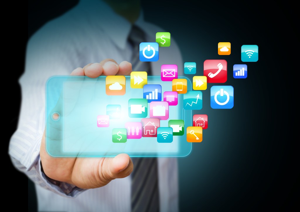 Business man holding a smart phone with apps flying out of it.