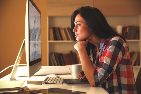 Female programmer looking intently at computer screen.