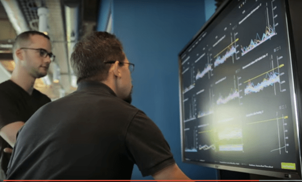 Two men looking at Google Stackdriver dashboards.