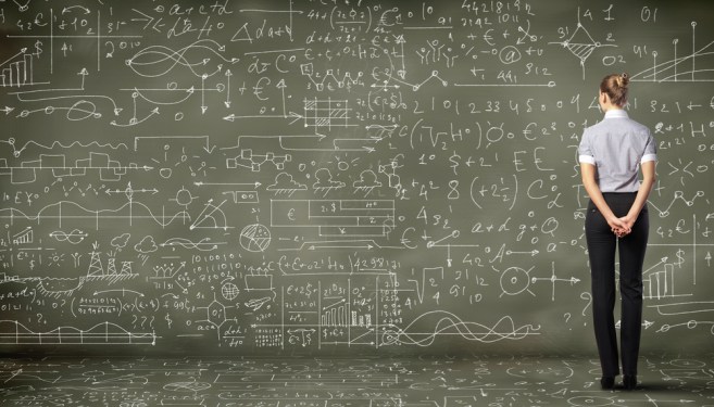 Data scientist in front of giant board with mathematical formulas.