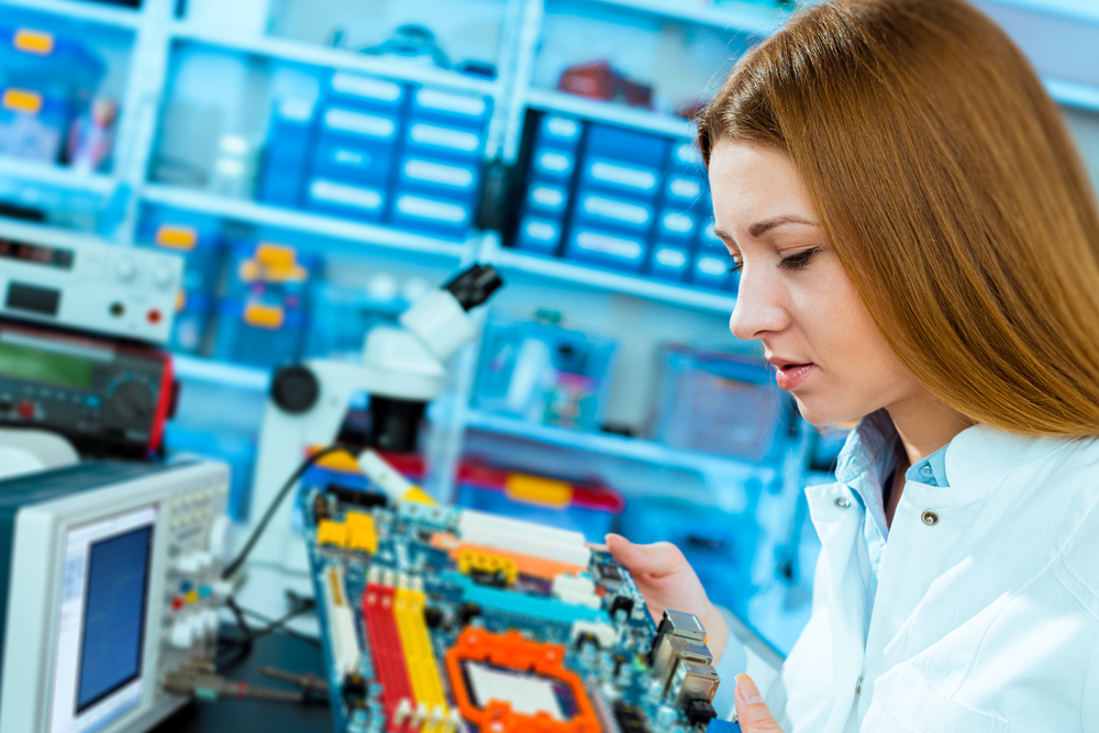 Woman working on circuit board at factory.