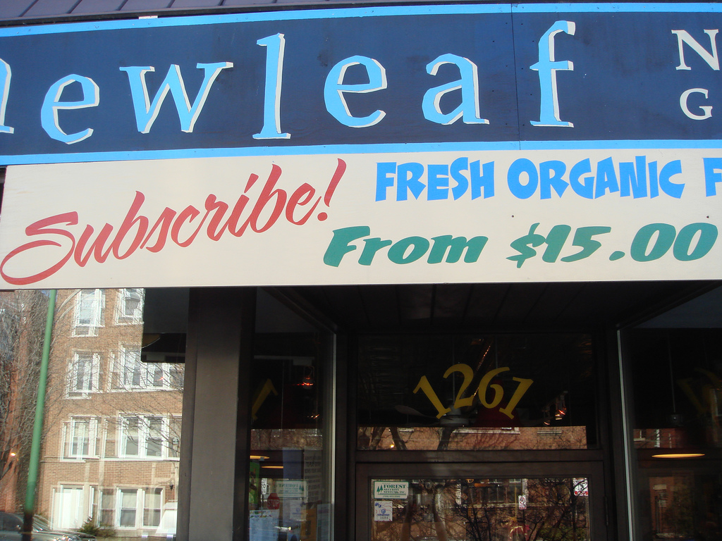 Sign on market offering subscriptions for organic vegetables.