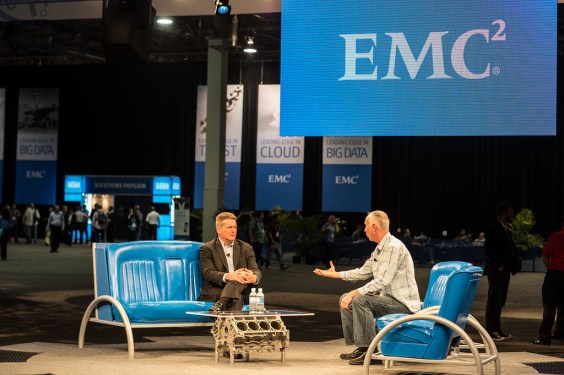 Two speaking under huge EMC banners.