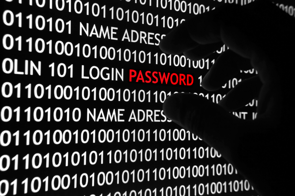 Black gloved hand grabbing red password from field of white zeros and ones to illustrate credential stealing.