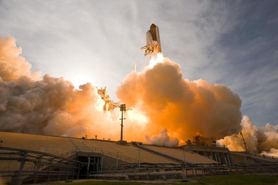 Space shuttle taking off firing booster rockets