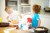 Boys in kitchen throwing flour at each other.