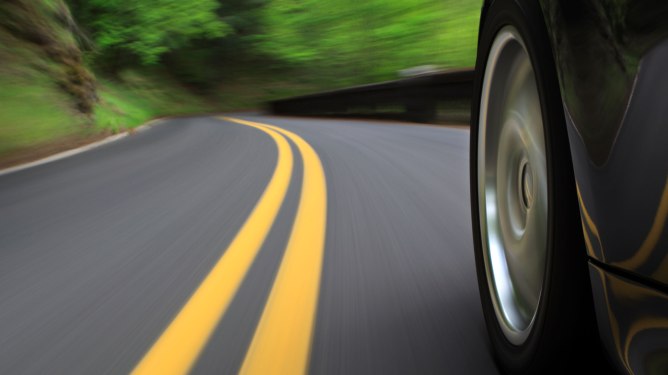 speeding car on road -closeup of tire