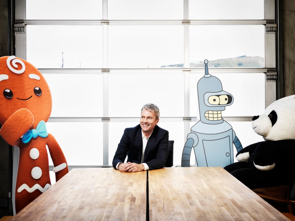 Chris DeWolfe posing with animated characters
