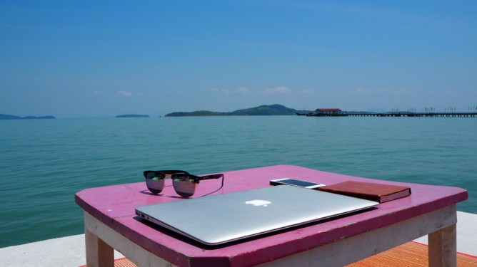 cloded laptop on table by the sea