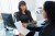 women talking across office desk