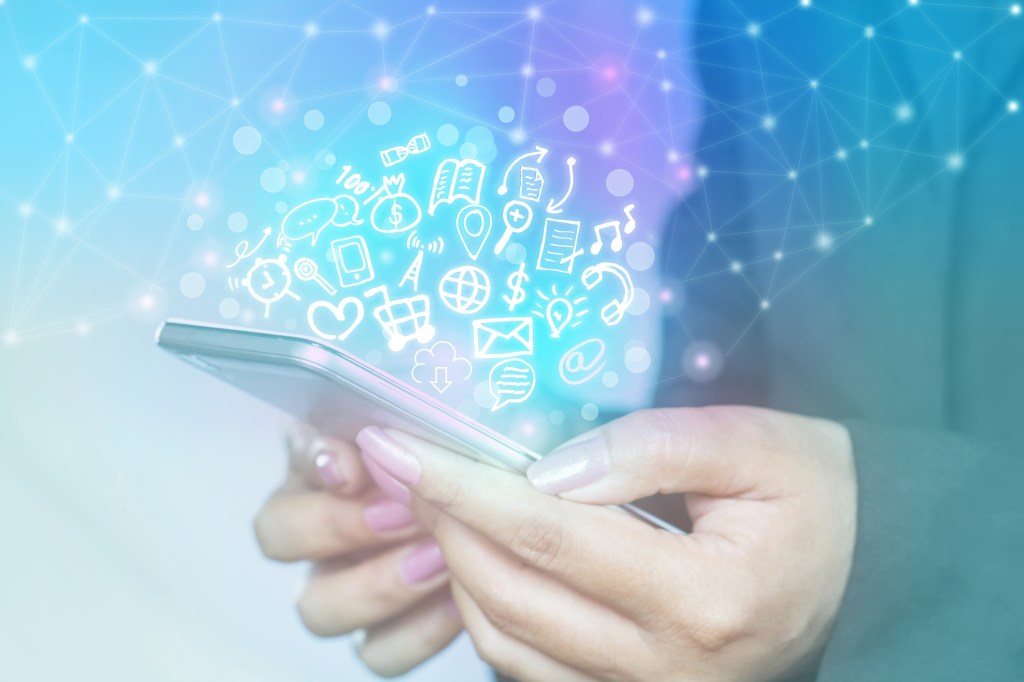 woman holding smartphone with technology icons popping out of the screen