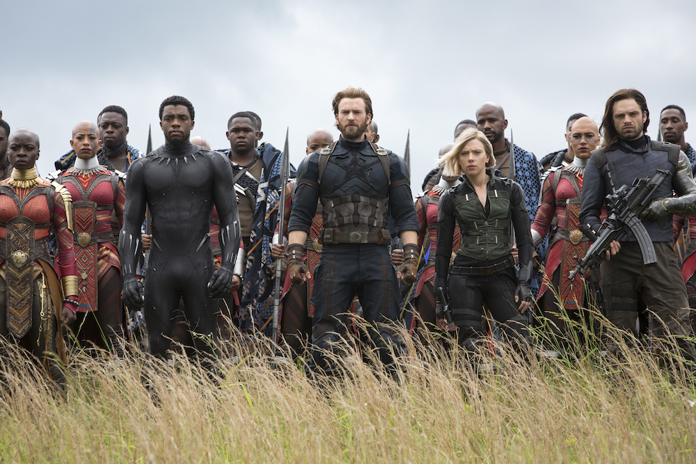 Marvel Studios' AVENGERS characters standing in field; poised for battle.