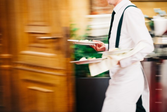 waiter whisking plates to table