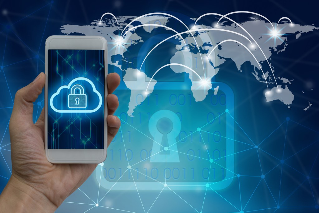 Cropped Hand Holding Smart Phone Against World Map