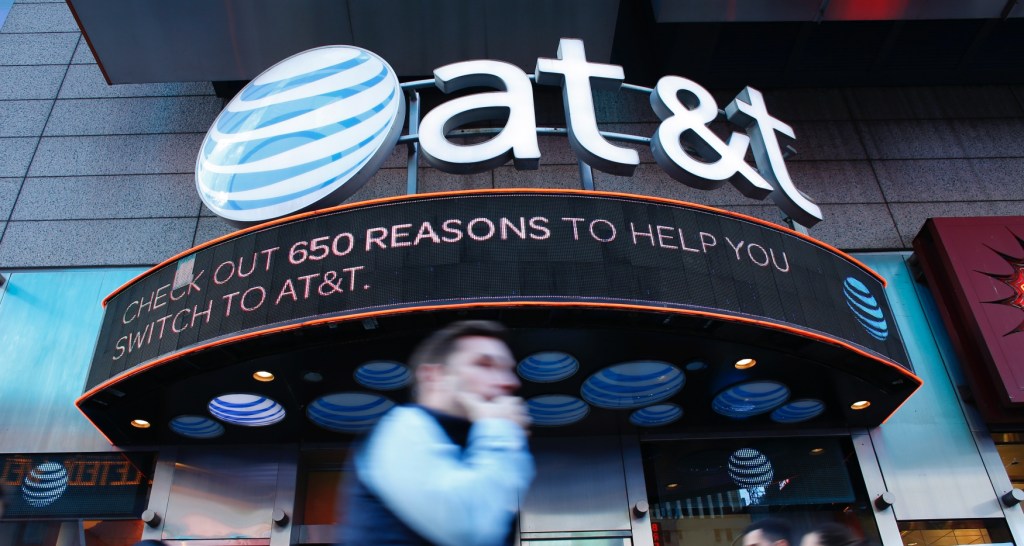 People walk past an AT&T store in New York on October 23, 2016.