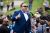 man standing at mic; Alex Jones