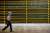 Image of a person walking past a wall of bitcoin mining rigs