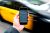 A taxi drives by a phone displaying the Uber app