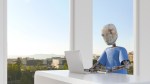 Robot working in office, using laptop