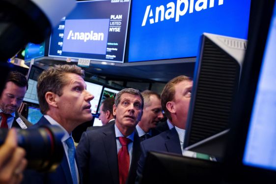 Steven Birdsall, chief revenue officer of Anaplan Inc., left, and Frank Calderoni, president and chief executive officer of Anaplan Inc., center, talk to a trader during the company's initial public offering (IPO) on the floor of the New York Stock Exchange (NYSE) in New York, U.S., on Friday, Oct. 12, 2018. U.S. stocks surged Friday after two days of market tumult as trade tensions with China seemed to ease, at least temporarily, with the countries planning to meet in November and the Treasury Department saying that China isn't manipulating its currency. Photographer: Michael Nagle/Bloomberg via Getty Images