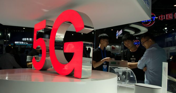 Attendees look at 5G mobile phones at the Qualcomm stand during China Mobile Global Partner Conference 2018 at Poly World Trade Center Exhibition Hall on December 6, 2018 in Guangzhou, Guangdong Province of China.