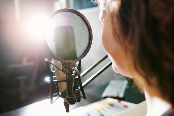 person sitting in front of a podcast mic
