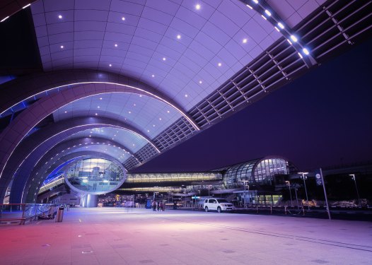 Illuminated Dubai International Airport at dusk, UAE