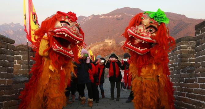 lion dance performers at the top of Mutianyu Great Wall to celebrate the New Year's Day