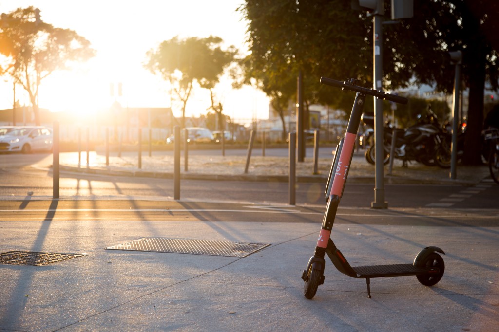 Voi scooter in Lisbon, setting sun in background
