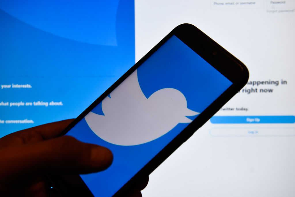In this photo illustration a Twitter logo seen displayed on