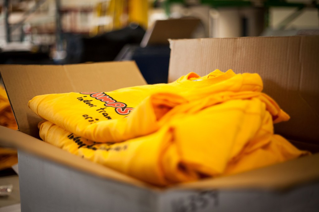 Open cardboard box containing screen printed t-shirts