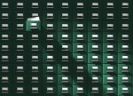 An immense card catalog system with one drawer pulled out, revealing a blank catalog card. This vintage database is floodlighted from the upper left side, giving it a mysterious edge.