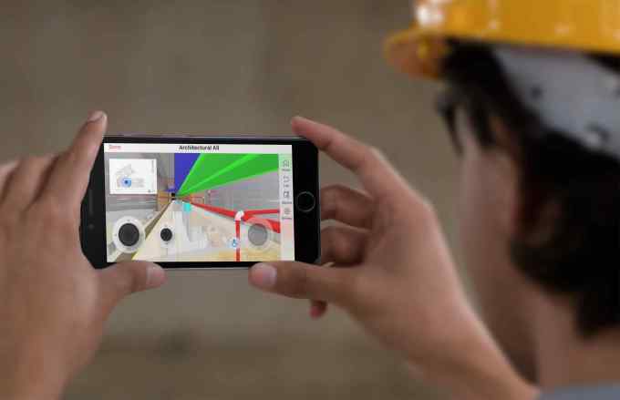 black iphone in landscape position held by a construction worker with a yellow hat a12584