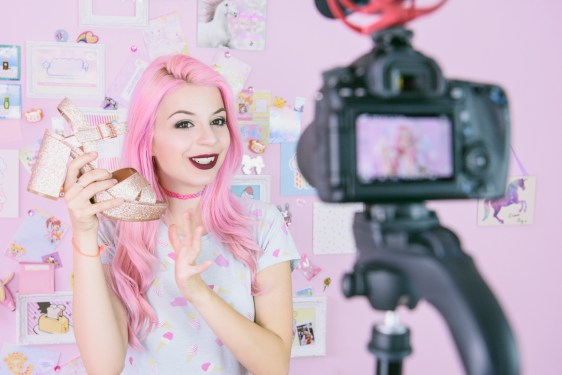 Social media influencer reviewing footwear, vlogging about women's fashion.