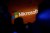 The Microsoft logo is illuminated on a wall during a Microsoft launch event