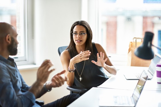 Woman and man talking in modern office.